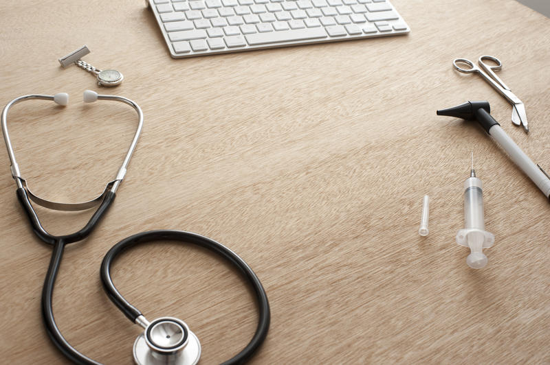 hand held medical diagnosis instruments and a computer keyboard, concept of doctors medical consultation