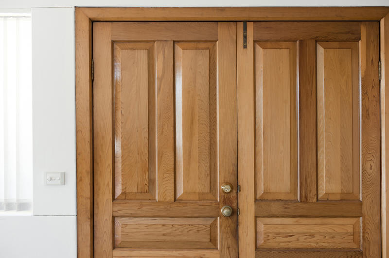 Close up on a Closed Wooden Double Home Door, Captured Inside the House with Locks.