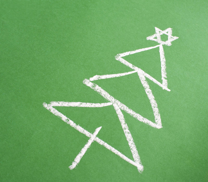 Simple hand-drawn chalk Christmas tree on a green blackboard with copyspace for your seasonal Xmas greeting