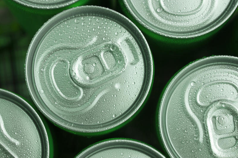 Close-up of several fresh cool cans with drops of water on top. From above