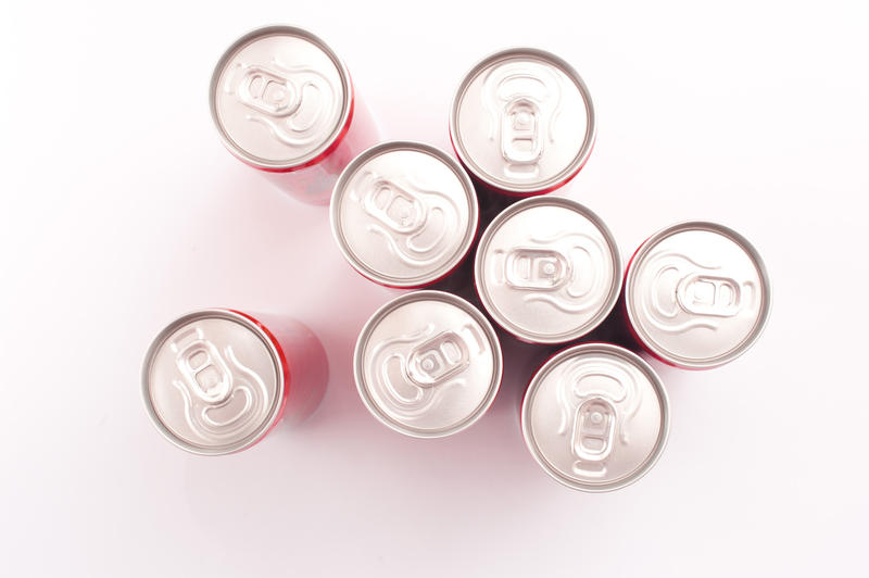 Assorted unopened drinks in cans viewed from overhead on a white background with copyspace