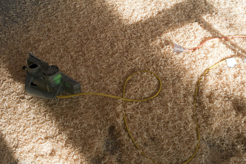 an electric woodworking plane on a background of wood shavings