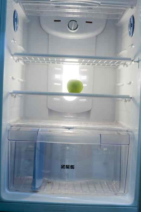 fridge empty but for a lone apple, concept of out of food, nothing to eat of a crash diet