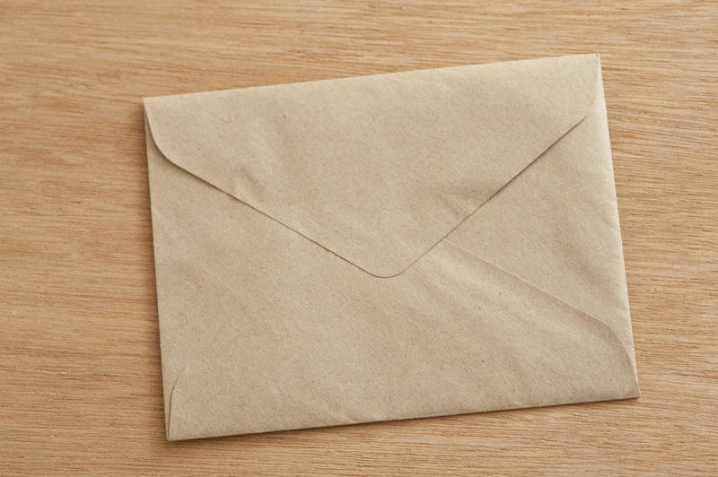 Close up Conceptual Closed Brown Envelope on Wooden Table, Emphasizing Copy Space