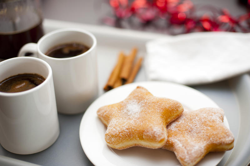 Christmas coffee break with festive star-shaped sugared doughnuts served with mugs of freshly brewed espresso coffee