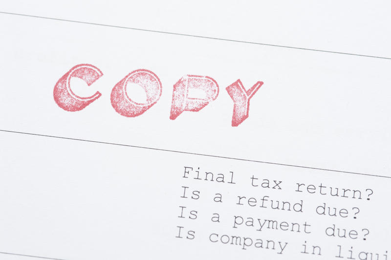 Close up One File Copy of Tax Paper with Label and Questions on White Background.