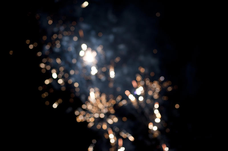 Sparkling background bokeh of bursting fireworks in a night sky celebrating a festival or holiday with copyspace to the right