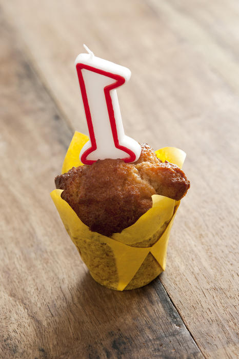 Close up Number 1 Candle on a Birthday Cupcake Placed on a Wooden Table.