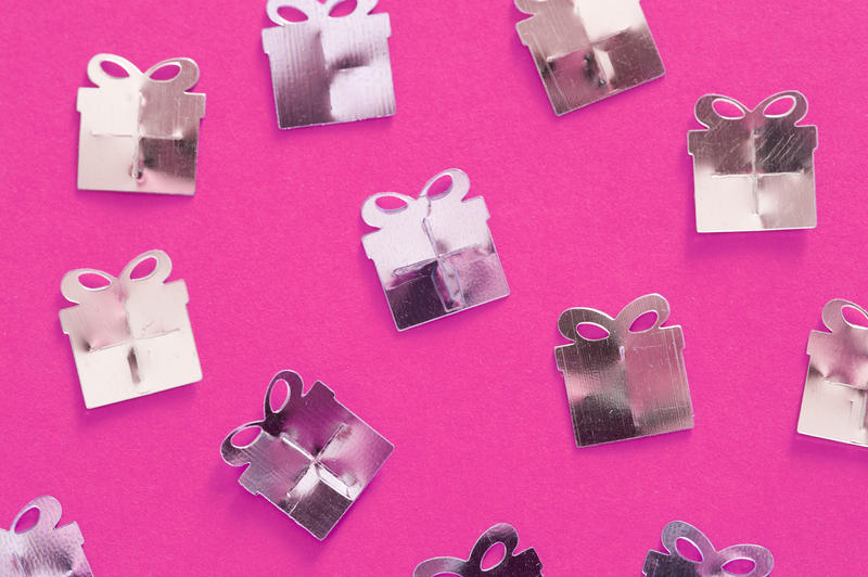 a feminine party gift background white metallic shapes on vibrant pink backdrop