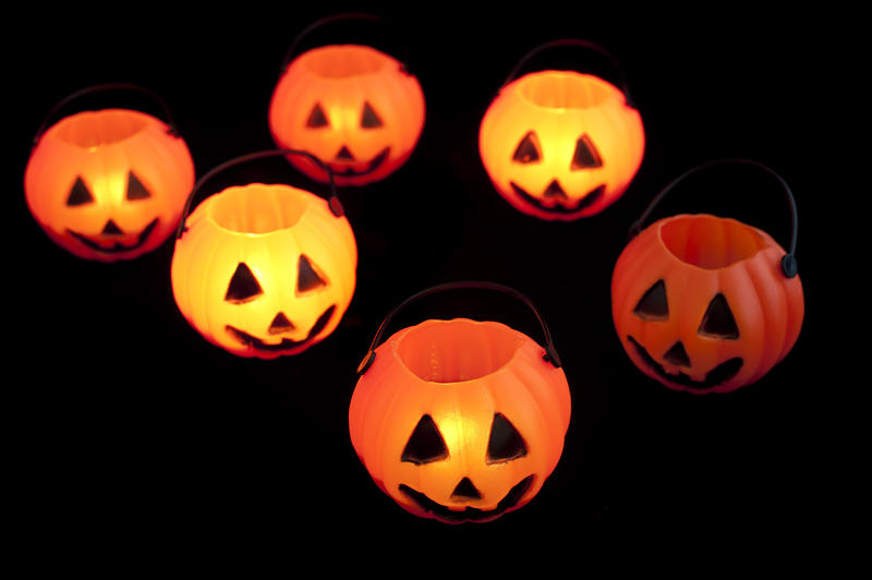 Group of orange pumpkin shaped glowing Halloween lantern decorations on a black background