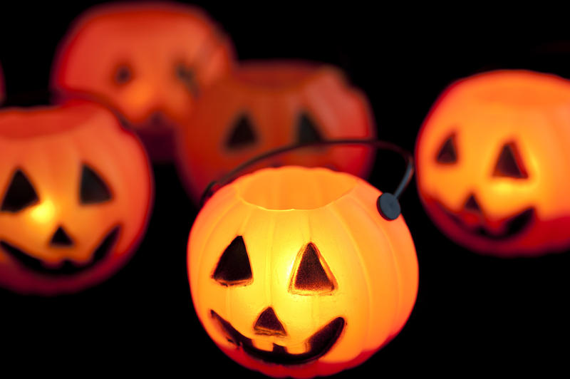 Glowing Halloween jack-o-lantern in the form of an ornamental pumpkin with a cut out face to celebrate the festival