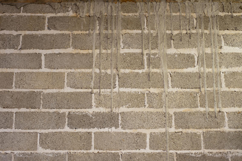 Close Up of Grungy Weathered Grey Brick Wall with Dripping Sealant or Caulking