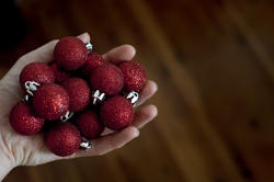 11690   Man holding a handful of Christmas baubles