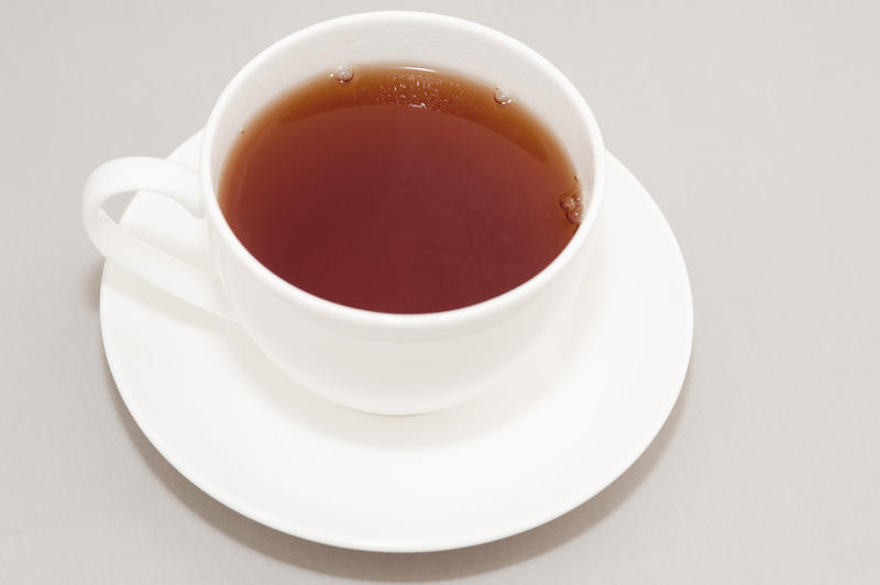 High Angle View of Hot Brewed Black Tea in Clean White Cup on Saucer in Studio with Neutral Gray Background