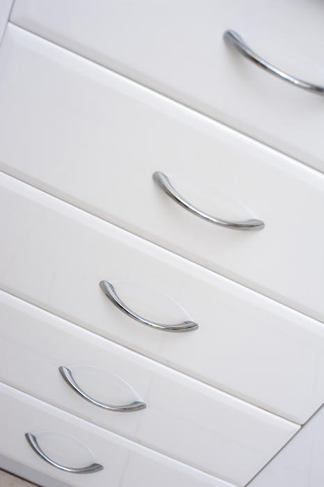 Set of clean fresh white kitchen drawers in a modern unit with simple metal handles
