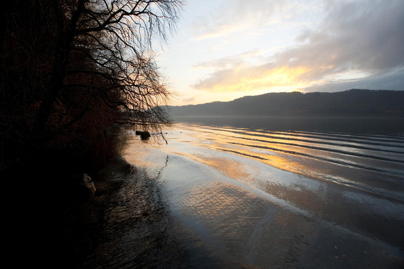 Beautiful tranquil sunset in the English Lake District with a delicate glow in the sky reflected in the calm water of the lake below