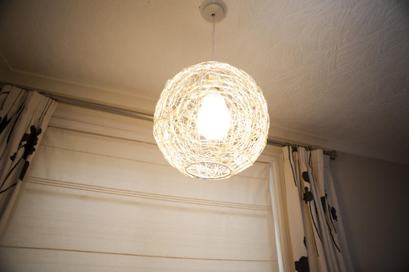 Elegant hand knitted wicker rattan ball pendant light hanging on the ceiling of a room