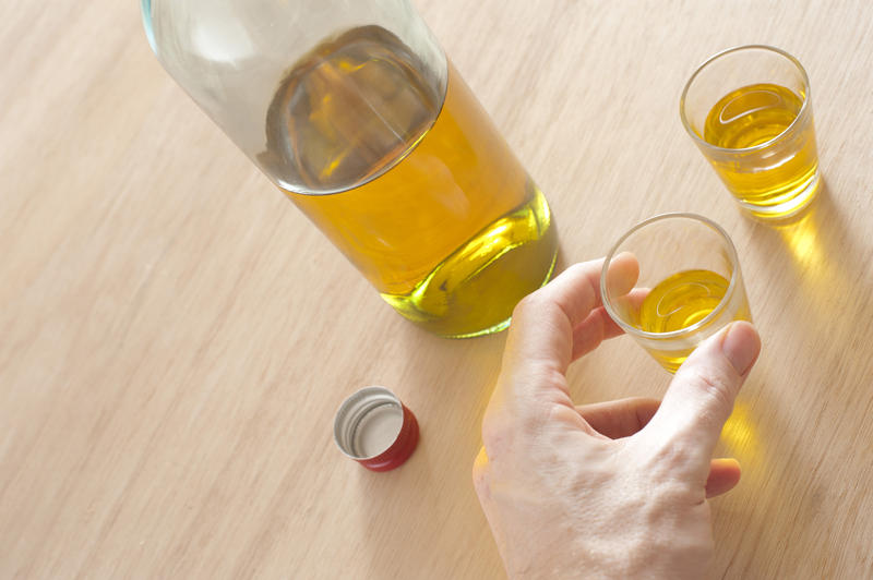 a bottle of rum and someone holding a shot glass