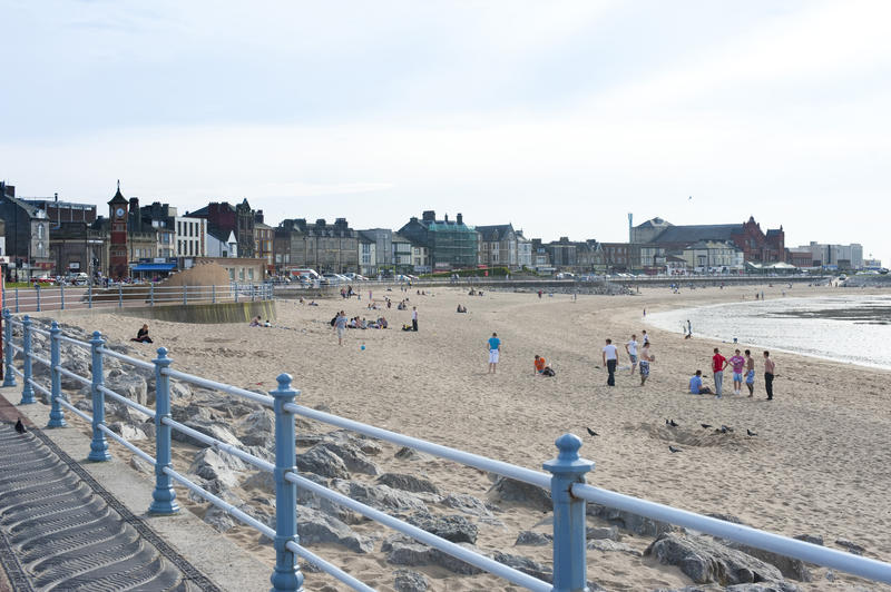 People relaxing enjoying the sunshine on Morecambe Beach, Lancashire