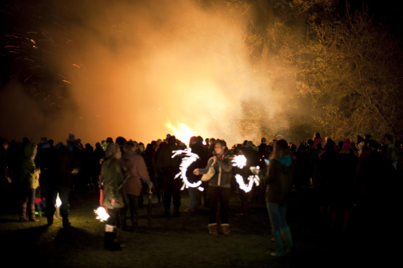 Crowd of people celebrating November 5th standing in front of a blazing bonfire commemorating Bonfire Night or Guy Fawkes - not model released