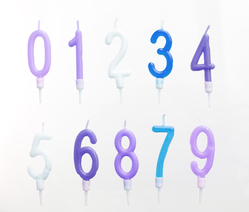 Set of isolated new unused number candles 0 through 9 to decorate anniversary and birthday cakes on a white background