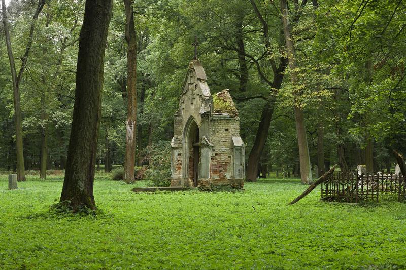 <p>Ruined Burial Vault on Green Grass at Old Cemetery.</p>