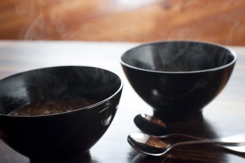 Two bowls of steaming hot onion soup for a tasty starter to a winter meal on a cold day