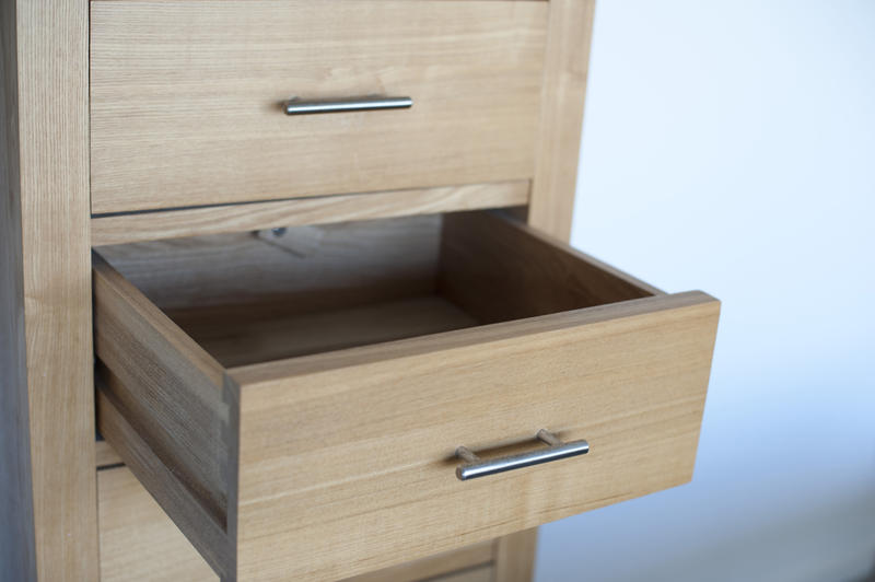 Close up Open Empty Light Brown Wooden Drawer Furniture Near a White Wall.