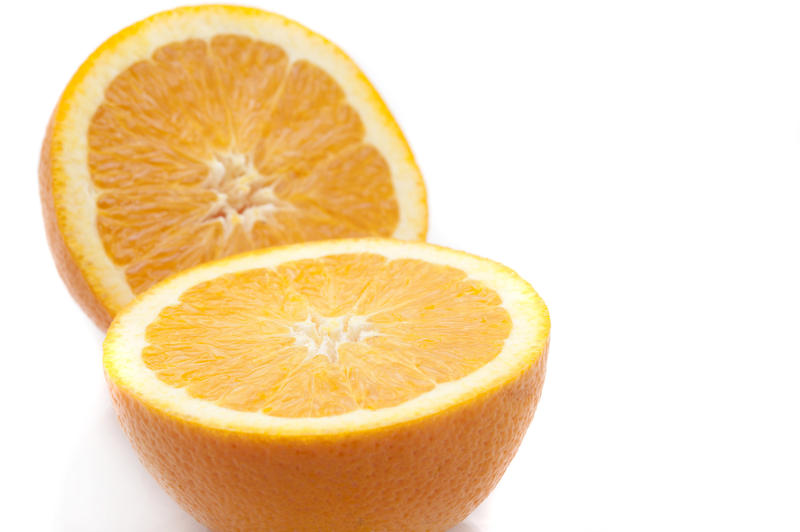 Close up view of a halved fresh sweet juicy orange on white with copyspace