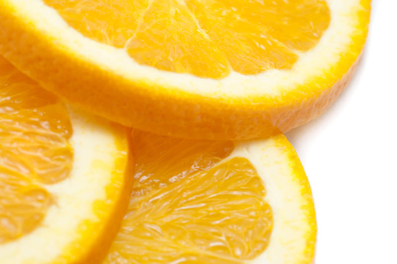 Close-up of three slices of a fresh tasty juicy orange, source of vitamin C, on white background