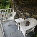 9850   Outdoors furniture on the porch of a stony house