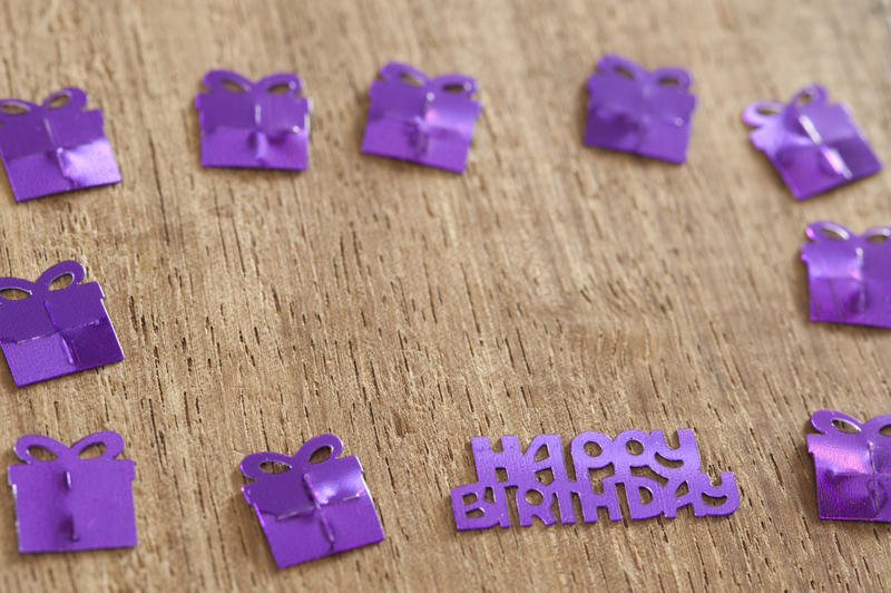 a wood background with purple gifts shapes and space for text in the center