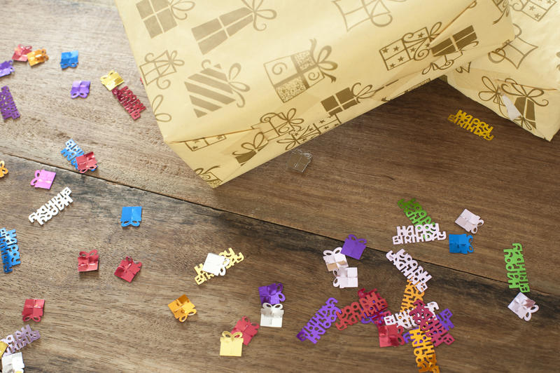 Close up Birthday Gifts Boxes and Colored Confetti on a Wooden Table