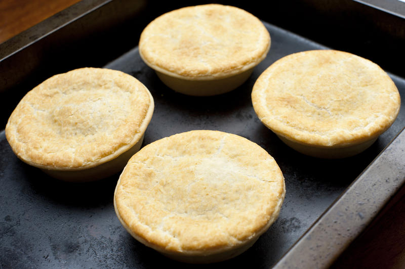 Close up Four Freshly Cooked Delicious Homemade Pies on a Black Tray for Snacks