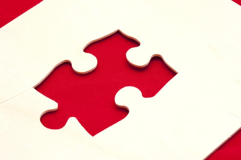 Close up One Pattern of Puzzle Piece on a White Board Placed on a Red Table.