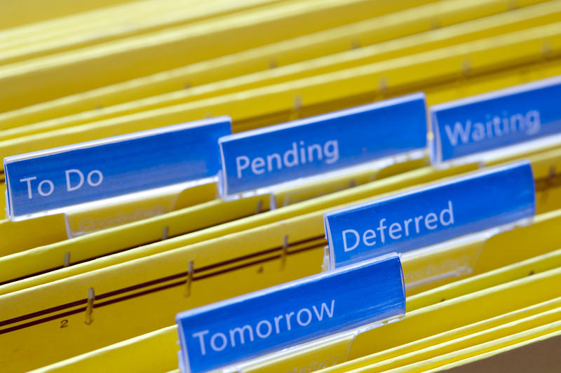 Simple Procrastination Concept - Close up Files on Yellow Folders with Blue Labels Emphasizing Tomorrow, Deferred, Waiting, Pending and To Do.