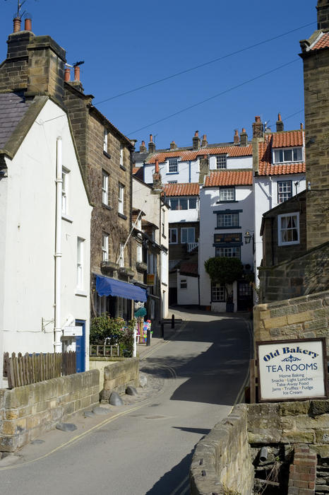 View of a quaint village street in Robin Hoods Bay fishing village on the Yorkshire Coast with old stone and white-washed buildings