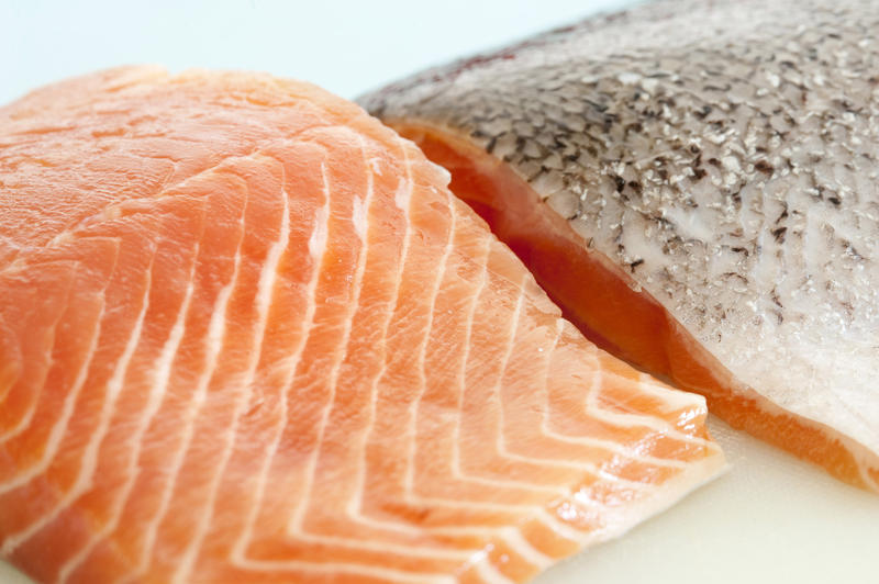 Two fresh uncooked salmon steaks one facing up showing the texture of the flesh and one facing down showing the skin for a healthy gourmet seafood dinner