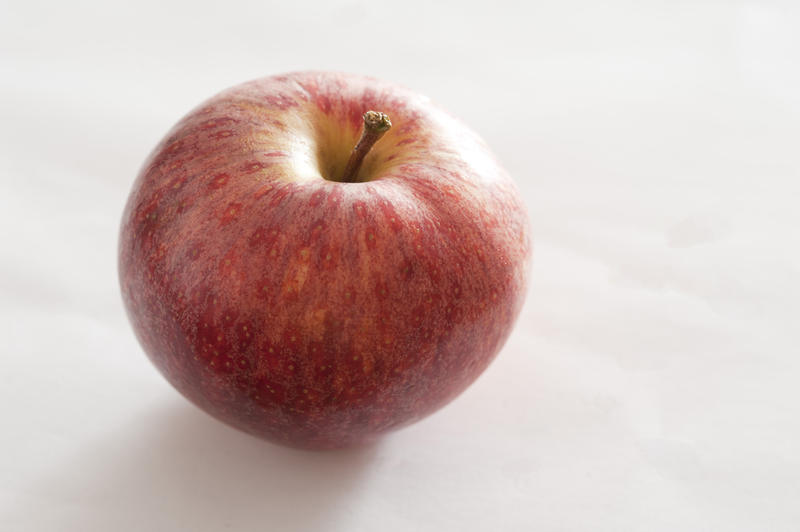 Close Up Still Life View of Single Ripe Red Apple on White Background with Copy Space