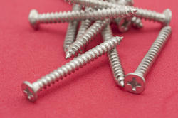10180   Pile of screws on a red background