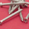 10180   Pile of screws on a red background