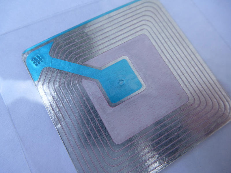 Close Up of Silver Radio Frequency Identification Security Tag with Blue Arrow
