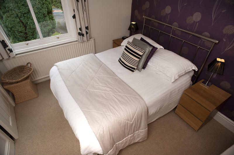 High angle view looking down into a small bedroom with a wrought iron bedstead