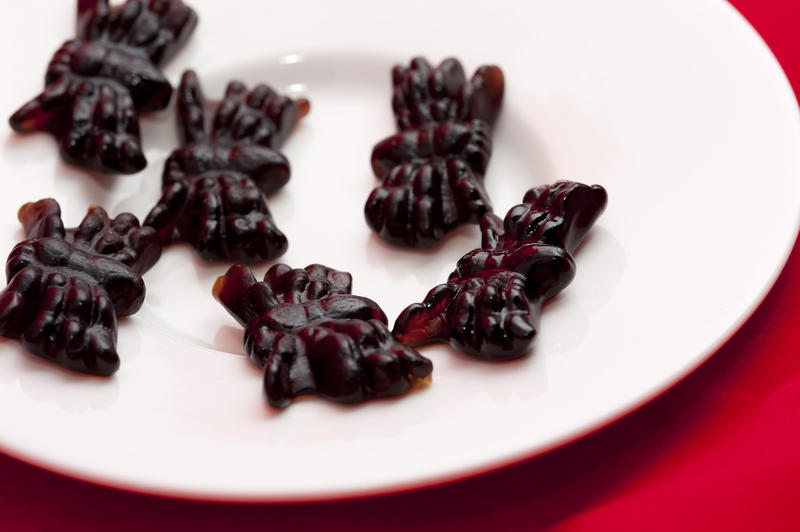 Black jelly spiders for Halloween displayed on a plate waiting for kids to come trick-or-treating