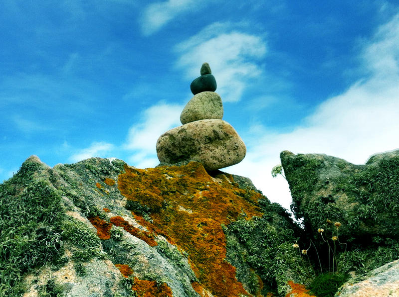 <p>Four stones stacked together on a rock - île de Bréhat, Brittany, France</p>
four stones stacked together on the top of a rock on Brehat Island in Britanny, France.