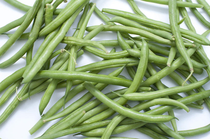 Close up Scattered Healthy Fresh String Beans Vegetables on Top of White Table.