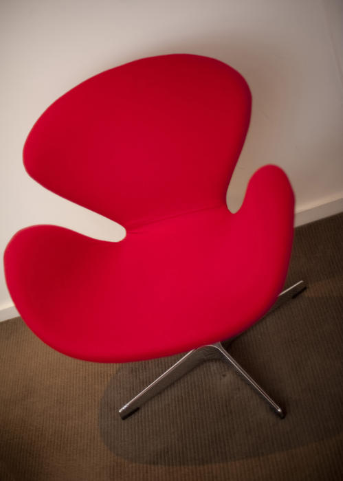 Contemporary red armchair with a funky modular design, close up high angle view on a brown carpet