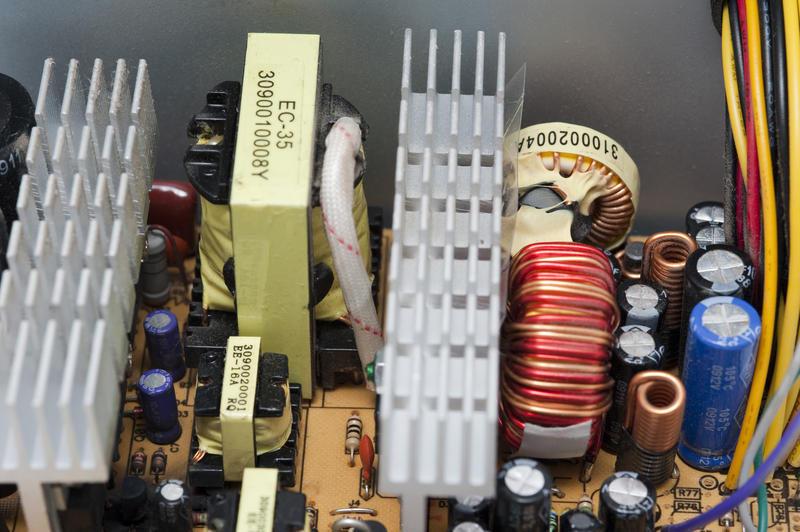 Components inside a switch mode power supply unit, transformer, heatsinks and several inductors