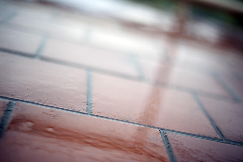 Close Up Abstract of Wet Brick Terracotta Tiles as part of Outdoor Patio Floor in Rainy Weather with Reflections