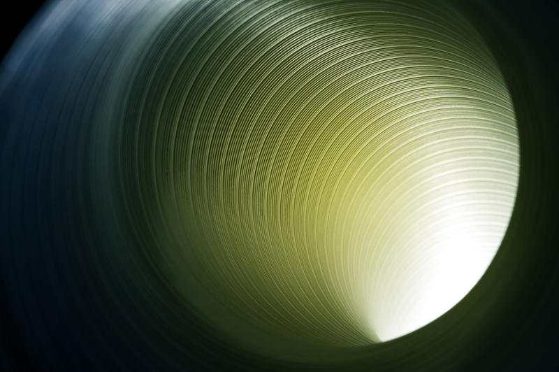 Beam of light shining through a hollow tube illuminating the spiral pattern of concentric circles in its structure
